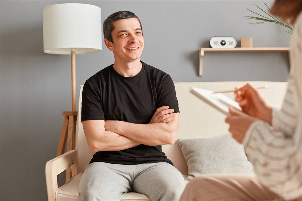 Homem sorrindo durante sessão de psicoterapia